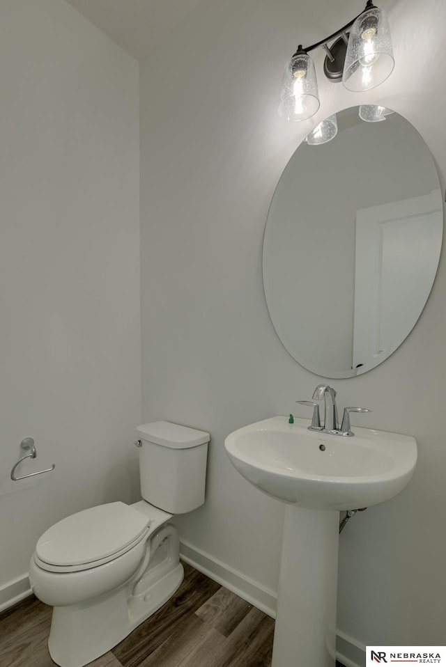 bathroom with hardwood / wood-style flooring, toilet, and sink