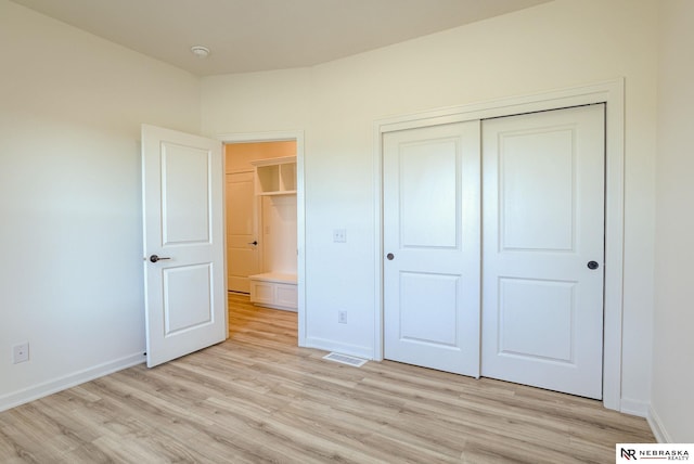 unfurnished bedroom with a closet and light wood-type flooring