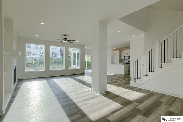 living room featuring hardwood / wood-style flooring, ceiling fan, and sink