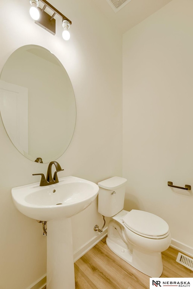 bathroom with hardwood / wood-style floors and toilet