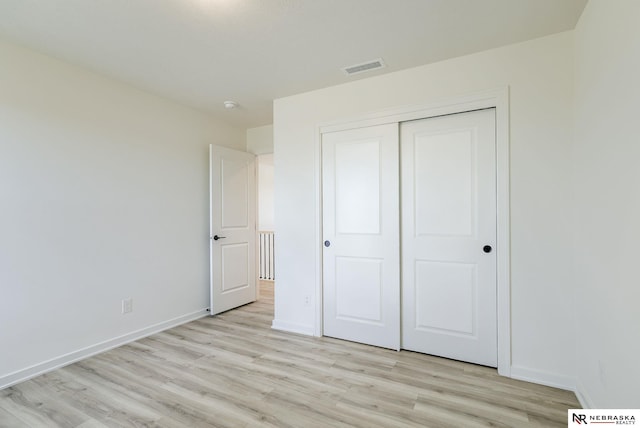 unfurnished bedroom featuring light hardwood / wood-style flooring and a closet