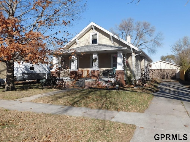 bungalow-style house featuring a front yard and covered porch