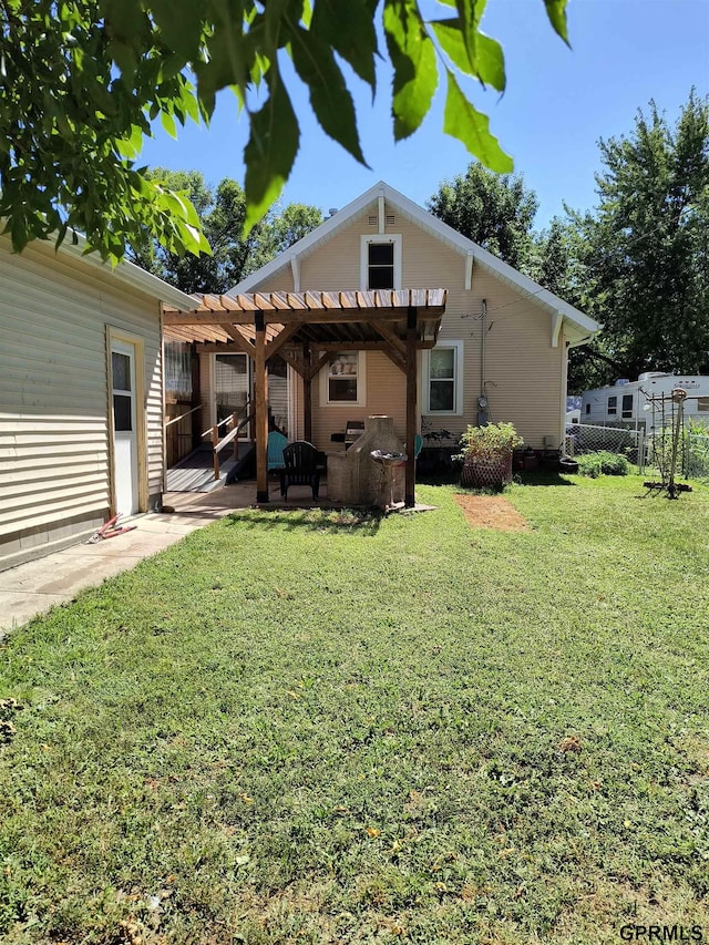 rear view of house with a yard and a pergola