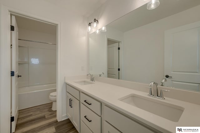 full bathroom with bathing tub / shower combination, vanity, hardwood / wood-style flooring, and toilet