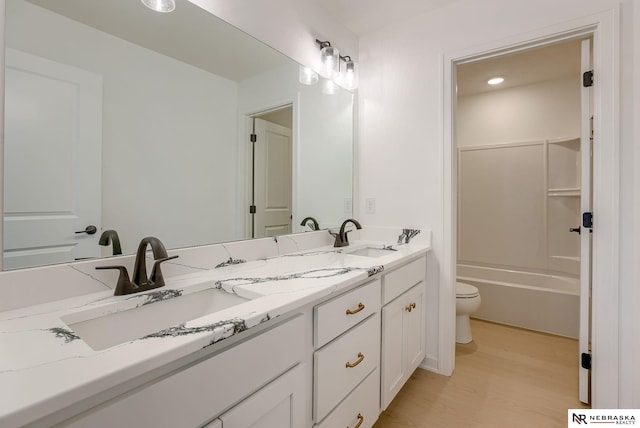 full bathroom featuring wood-type flooring, toilet,  shower combination, and vanity