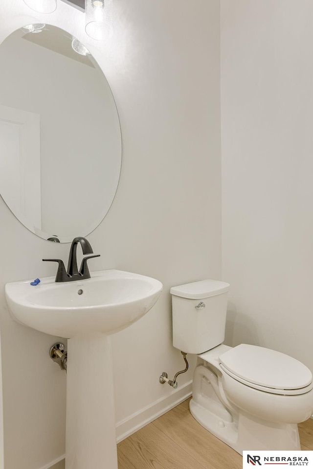 bathroom featuring hardwood / wood-style flooring and toilet