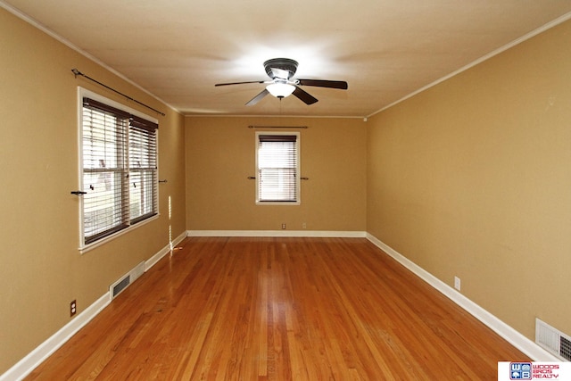 empty room with hardwood / wood-style floors, ceiling fan, a healthy amount of sunlight, and ornamental molding