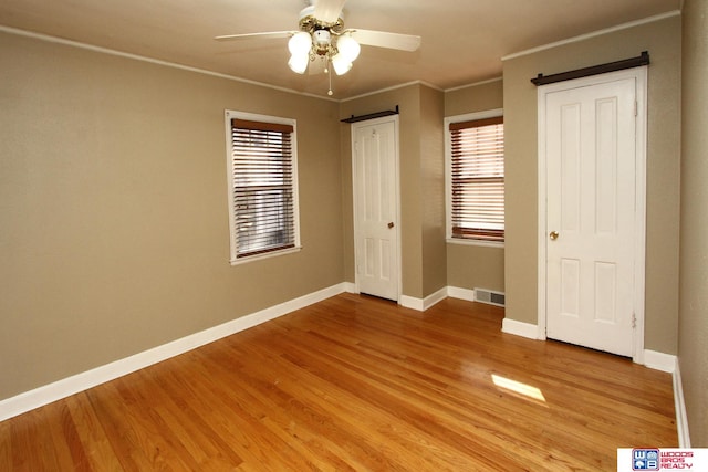 unfurnished bedroom with ceiling fan, light hardwood / wood-style floors, and ornamental molding