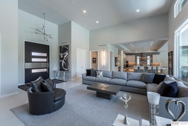 living room with light tile patterned floors, a high ceiling, and an inviting chandelier