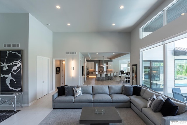 living room featuring light tile patterned floors and a high ceiling