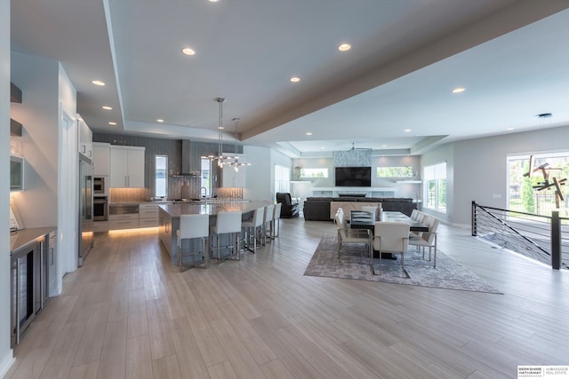 dining space featuring a fireplace, light hardwood / wood-style floors, and a chandelier