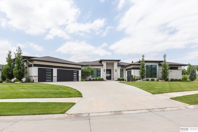 prairie-style house featuring a garage and a front yard