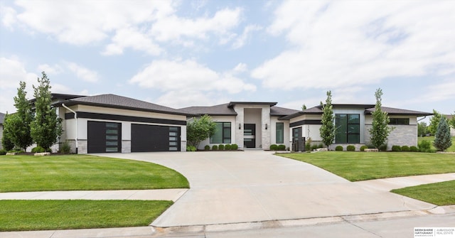 prairie-style home featuring a front lawn and a garage