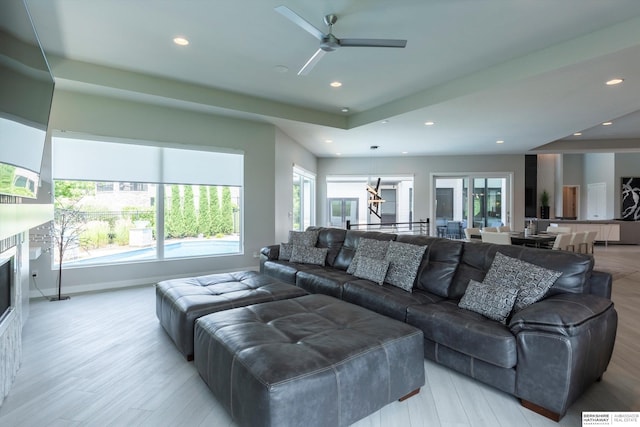 living room featuring light hardwood / wood-style flooring and ceiling fan