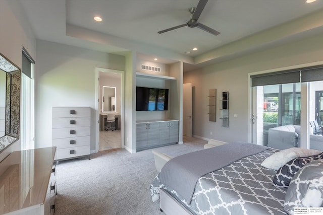 carpeted bedroom featuring a raised ceiling, ceiling fan, and access to exterior