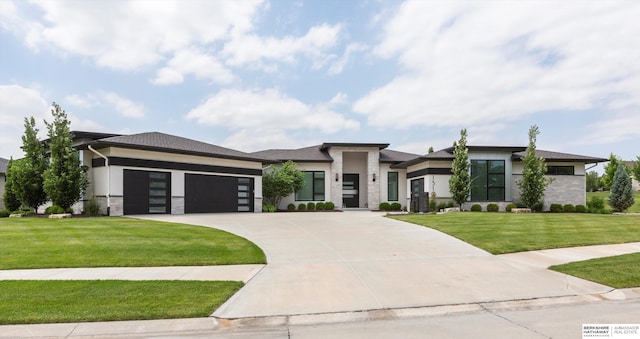 prairie-style home featuring a garage and a front lawn