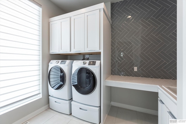 laundry room with washing machine and dryer, sink, light tile patterned flooring, and cabinets