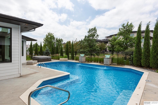 view of pool featuring pool water feature, a patio, and a hot tub