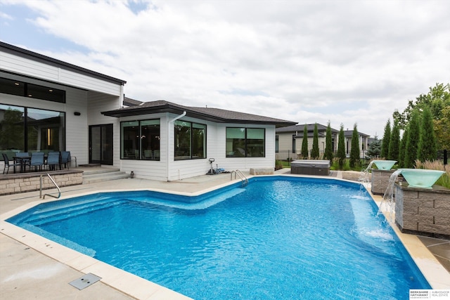 view of pool featuring pool water feature, a patio, and a hot tub