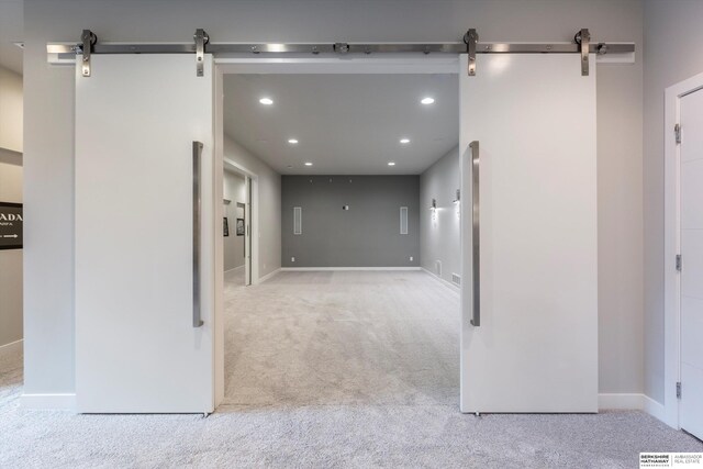 interior space featuring light carpet and a barn door