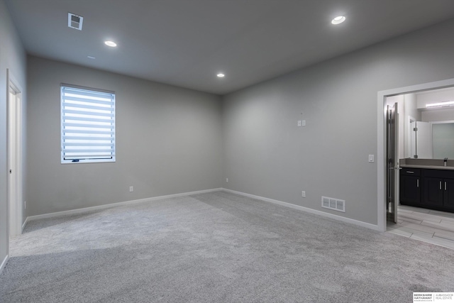 carpeted spare room featuring sink