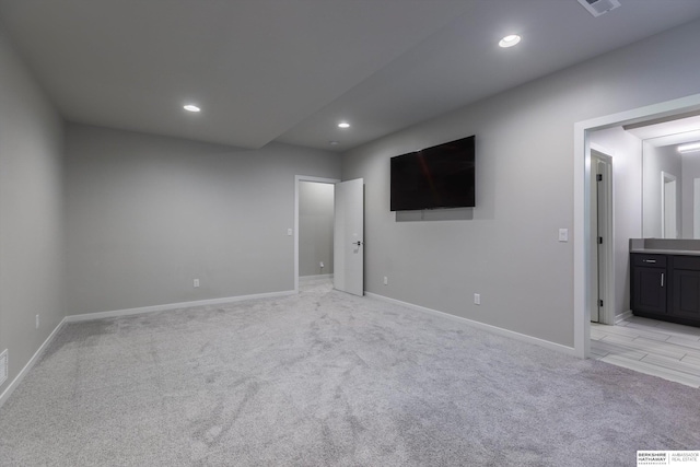 unfurnished bedroom with connected bathroom and light colored carpet