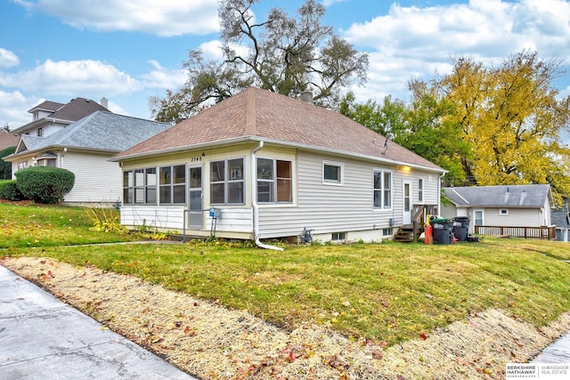 view of side of home with a sunroom and a lawn