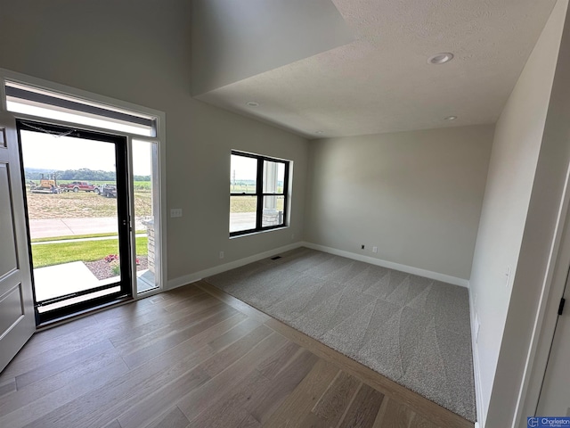 interior space featuring a textured ceiling and hardwood / wood-style flooring