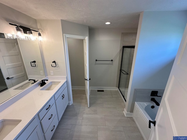 bathroom featuring tile patterned floors, plus walk in shower, vanity, and a textured ceiling