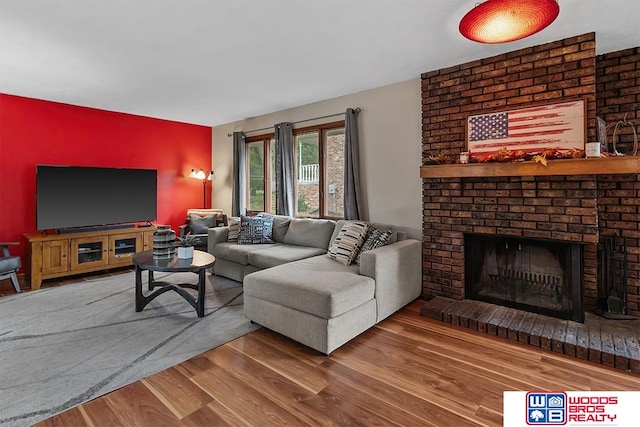 living room featuring hardwood / wood-style flooring and a brick fireplace