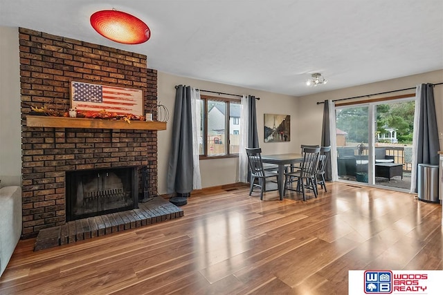 dining area featuring a fireplace and wood-type flooring