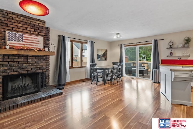 living room featuring hardwood / wood-style flooring and a brick fireplace