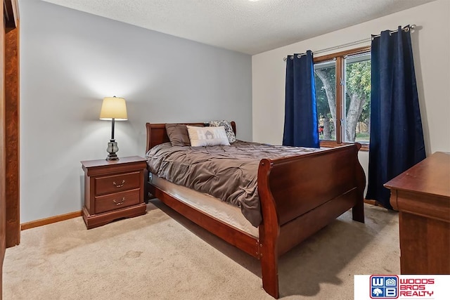 bedroom featuring light carpet and a textured ceiling