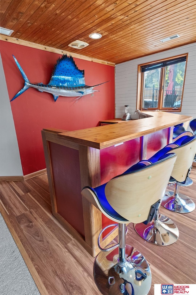 bar featuring hardwood / wood-style flooring, wooden ceiling, and ornamental molding