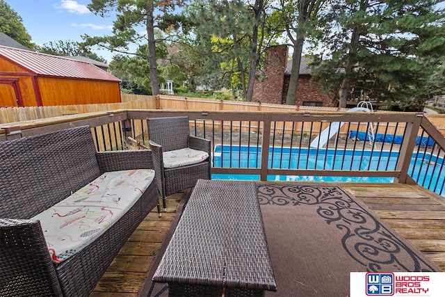 wooden terrace featuring a fenced in pool and an outdoor living space