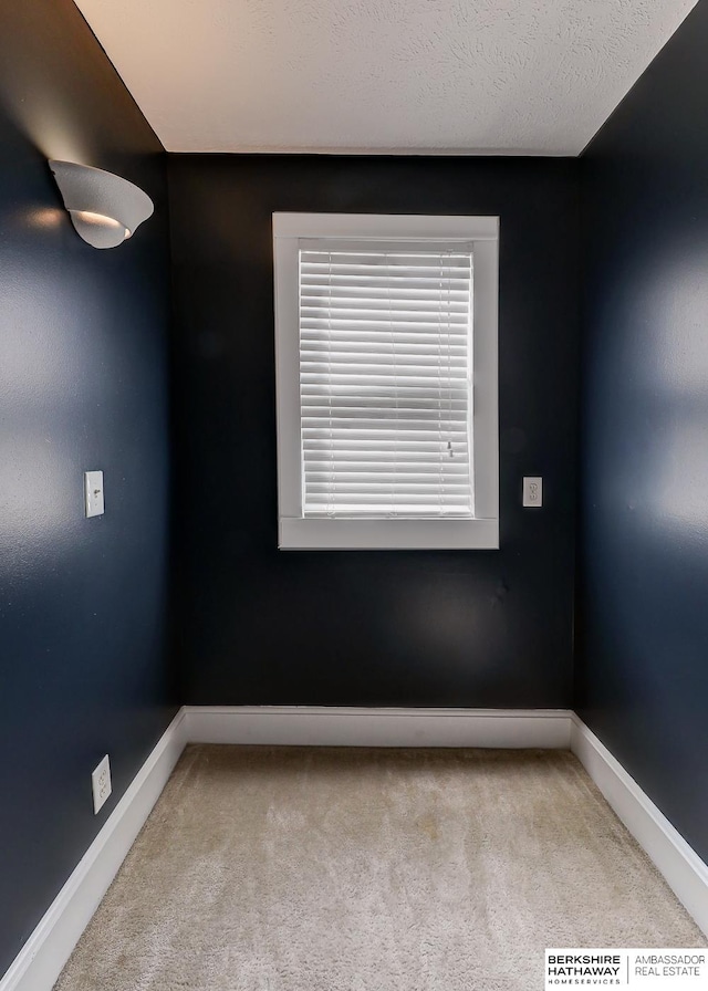 unfurnished room featuring light carpet and a textured ceiling