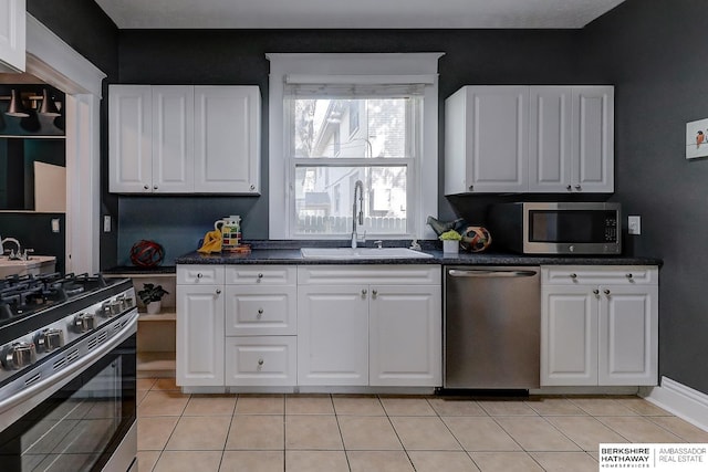 kitchen featuring light tile patterned floors, stainless steel appliances, white cabinetry, and sink