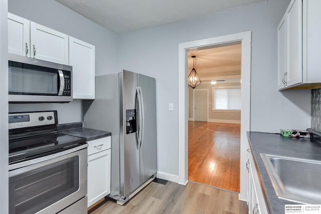 kitchen with white cabinetry, sink, light hardwood / wood-style floors, and appliances with stainless steel finishes