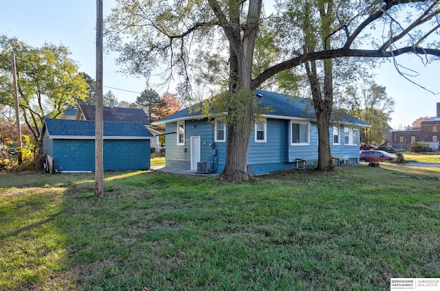 view of side of home featuring an outbuilding and a yard