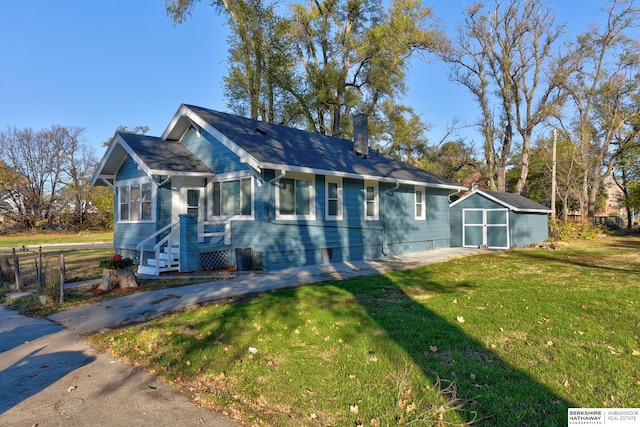 view of front of home featuring a shed and a front lawn