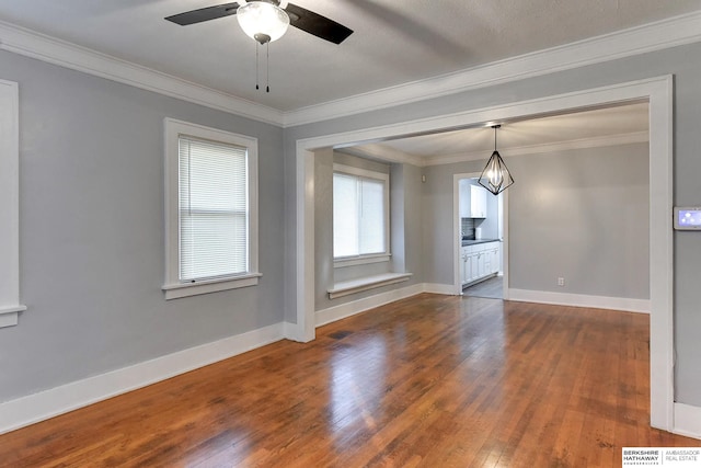 unfurnished dining area with ceiling fan, dark hardwood / wood-style floors, and ornamental molding