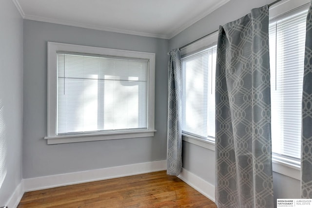 unfurnished room with a healthy amount of sunlight, wood-type flooring, and crown molding