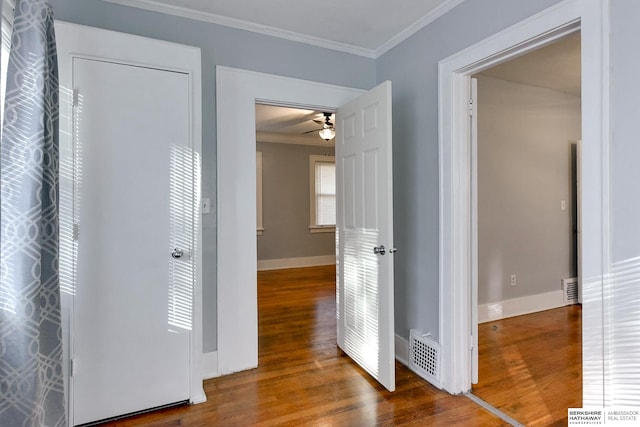 corridor with hardwood / wood-style flooring and crown molding