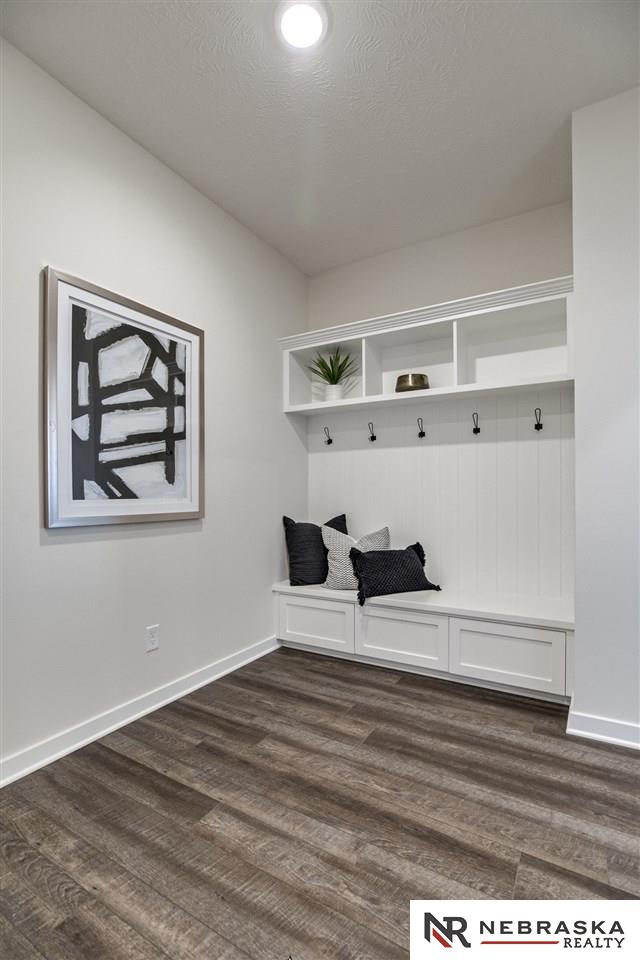 mudroom with a textured ceiling and dark wood-type flooring