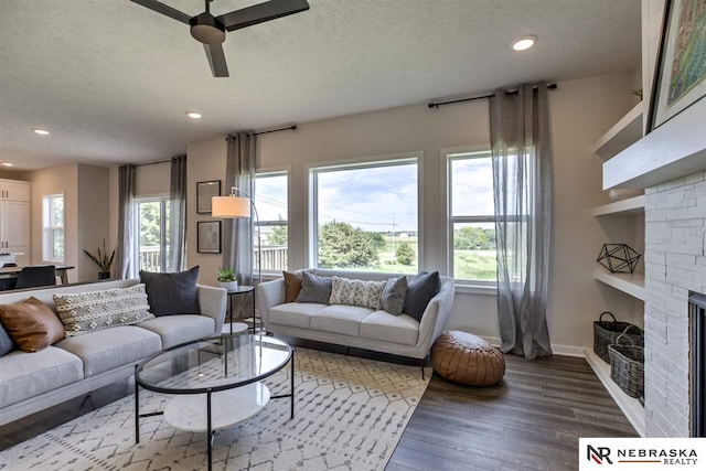 living room with ceiling fan, hardwood / wood-style floors, and a textured ceiling