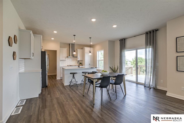 dining space featuring a textured ceiling, dark hardwood / wood-style flooring, and sink