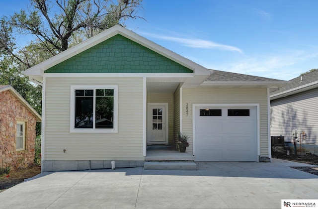 view of front facade featuring central AC unit and a garage