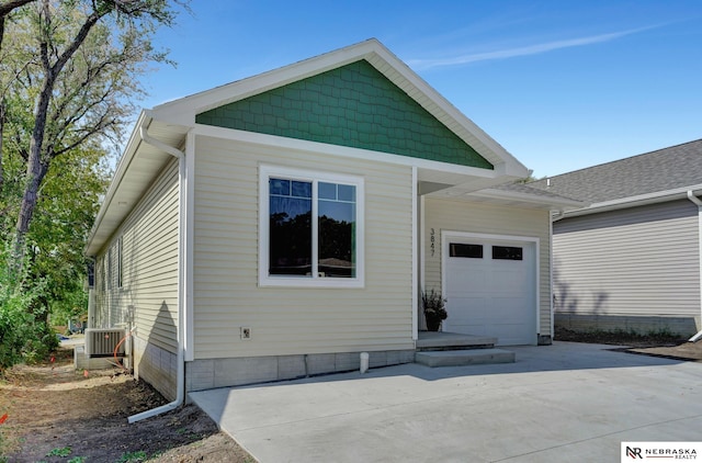 view of front facade featuring central AC unit and a garage