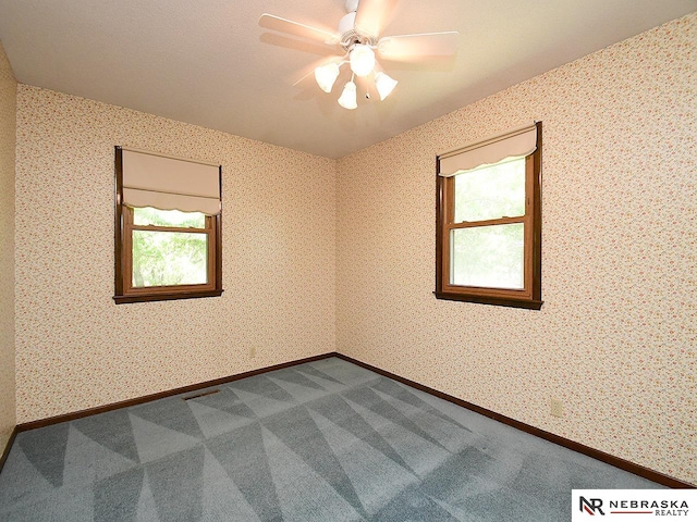 carpeted spare room with ceiling fan