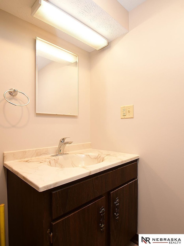 bathroom featuring a textured ceiling and vanity